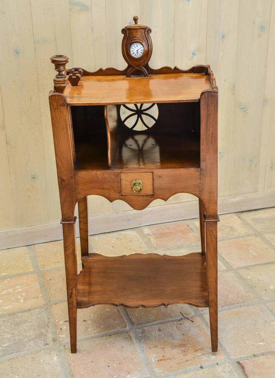 Incorporating a candleholder and a covered urn enclosing a pocket watch; fitted with a frieze drawer; with pierced decoration on sides and back.